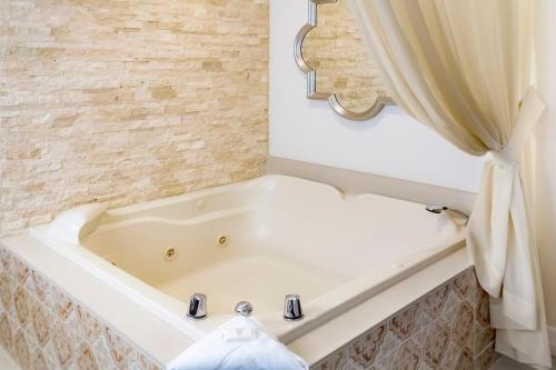 a white bath tub sitting next to a white sink at Westgate Flamingo Bay Resort in Las Vegas