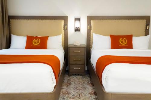 two beds in a hotel room with orange pillows at Westgate Flamingo Bay Resort in Las Vegas