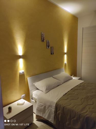 1 dormitorio con 1 cama y 2 luces en la pared en La Chianca, en Leverano