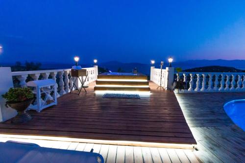 a wooden boardwalk with stairs on a balcony at night at Eva's Luxury Villa in Kritharia