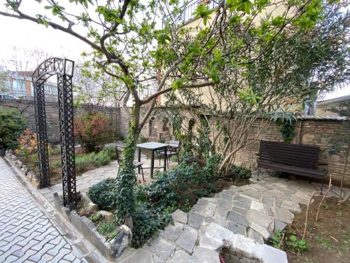 a park bench sitting next to a wall with a tree at Wine Hills in Tbilisi City
