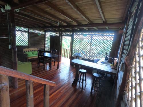Eco Guest House- Sarapiquí 2 في سارابيكي: غرفة طعام في كابينة خشب مع طاولة وكراسي