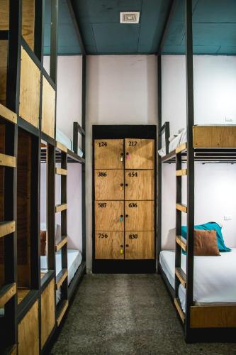 pokój z trzema łóżkami piętrowymi i drzwiami w obiekcie Hostal Sole w mieście Santa Ana