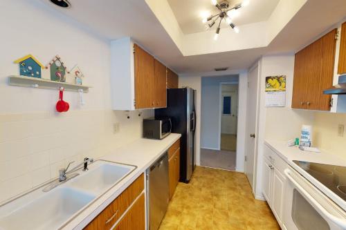 a kitchen with a sink and a refrigerator at Mangrove View on Oyster Creek in Englewood