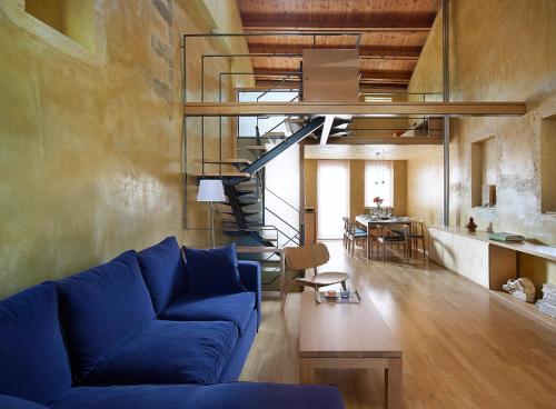 a living room with a blue couch and a staircase at Dorotheou House in Chania