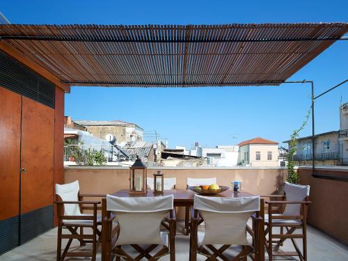 Un patio con una mesa y sillas en un balcón. en Dorotheou House, en La Canea