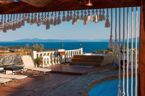 a wooden deck with chairs and a swimming pool at Eva's Luxury Villa in Kritharia