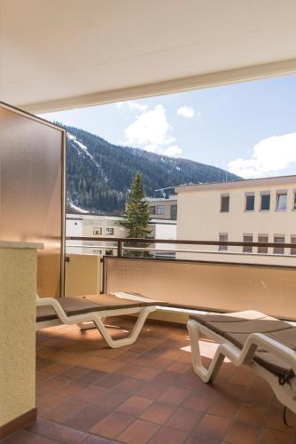 a balcony with a bench and a large window at Spenglers Inn in Davos