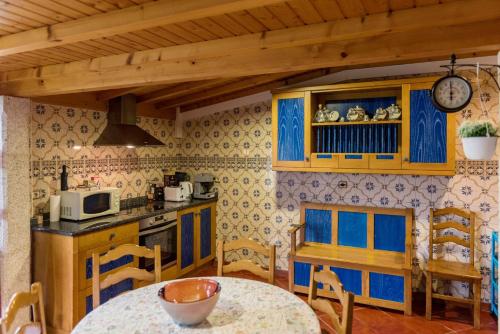 a kitchen with blue cabinets and a table with a tableablish at Michel's house in Esposende