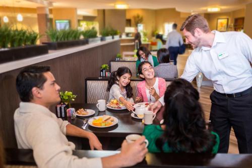 a group of people sitting around a table in a restaurant at Holiday Inn Indianapolis - Airport Area N by IHG in Indianapolis