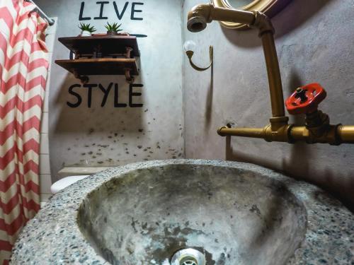 lavabo de piedra en el baño con pipa en Hostal Sole, en Santa Ana
