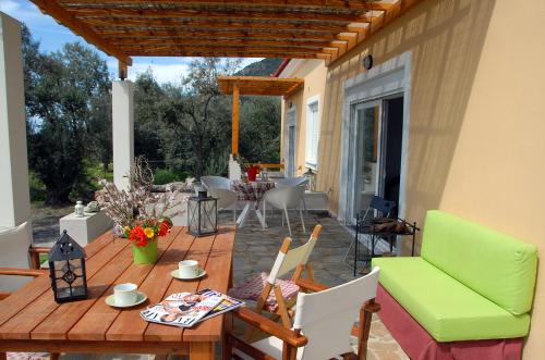 een houten terras met een tafel en stoelen op een patio bij Melinda Holiday House in Plomarion