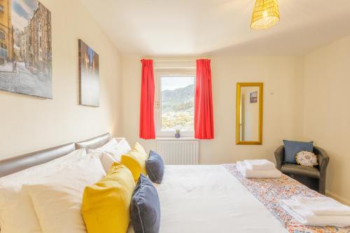 a bedroom with a bed and a window with red curtains at Pleasance Apartment in Edinburgh