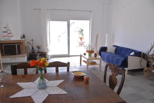 ein Wohnzimmer mit einem Tisch und einem blauen Sofa in der Unterkunft Melinda Holiday House in Plomari