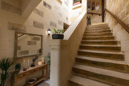 a staircase in a building with a mirror and plants at Sweet Life Gozo - Boutique Living in Santa Luċija