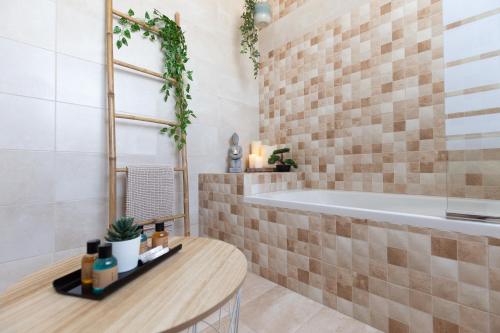 a bathroom with a tub and a table and a sink at Sweet Life Gozo - Boutique Living in Santa Luċija