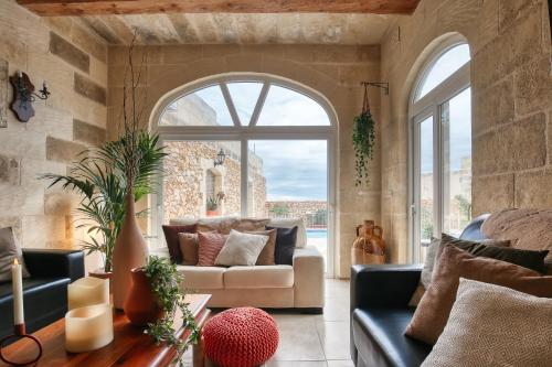 a living room with a couch and a large window at Sweet Life Gozo - Boutique Living in Santa Luċija