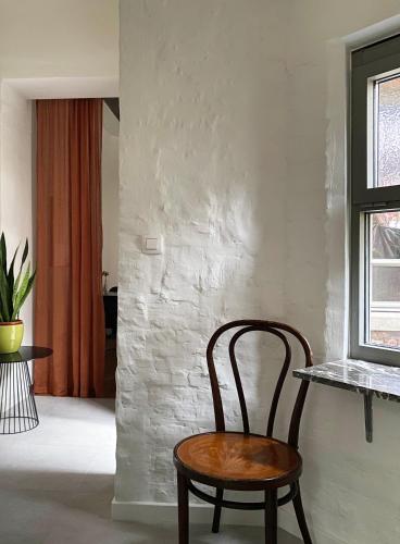 a wooden chair in a room with a window at B&B Expo House in Antwerp
