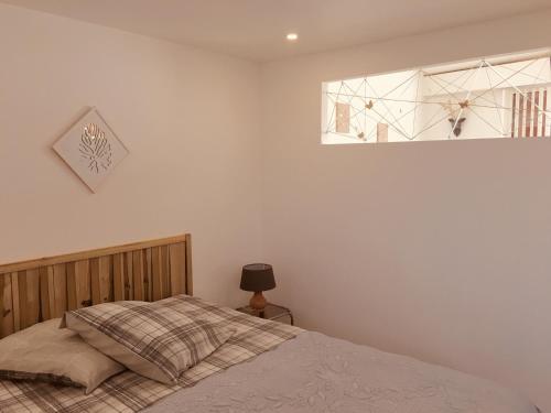 une chambre avec un lit et une fenêtre dans l'établissement Le Clos des Gites, maisons de vacances,, à Châteauneuf-Val-Saint-Donat