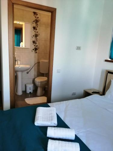 a bedroom with a bed and a bathroom with a sink at Pensiunea Corina Tulcea in Tulcea