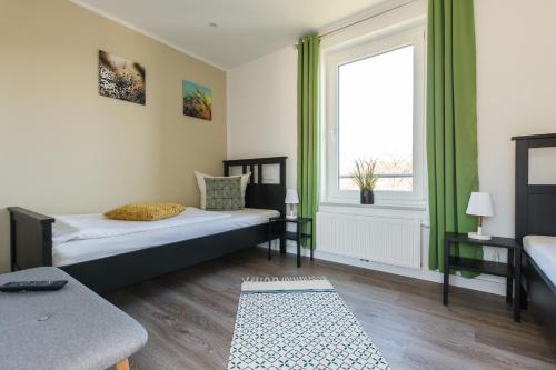 a bedroom with a bed and a large window at Luftkurort - 5 Sterne Ferienhaus - See-Kamin-Sauna-Garten in Krakow am See