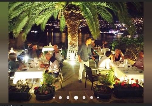 a group of people sitting at tables in a restaurant at Sea view Bougainvillea 52 in Kalkan