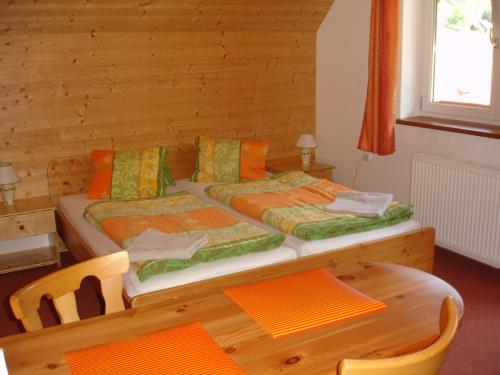 a bedroom with a bed and a table and chairs at Pension Stoder in Hinterstoder