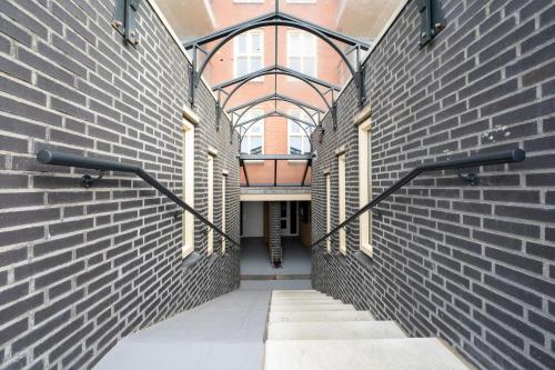 an empty hallway in a brick building with a window at DE TRINTEL met zeezicht in Egmond aan Zee