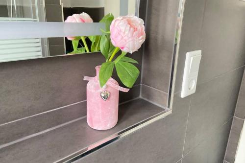 a pink vase with a pink flower in it at STAYWELL Zentral für 4 I Küche I Parkplatz I Netflix in Paderborn