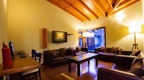 ein Wohnzimmer mit Sofas und einem Tisch in der Unterkunft Hotel Poincenot in El Chalten