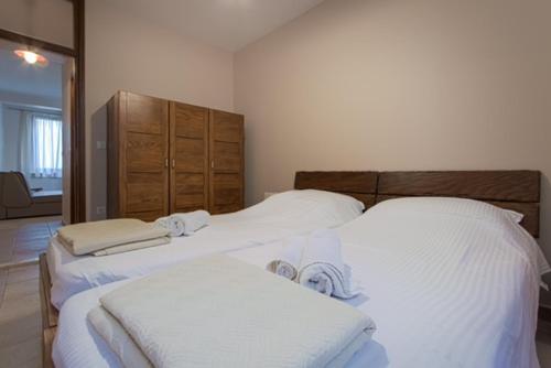 una camera da letto con due letti con lenzuola bianche di Villa Nikolina a Žman