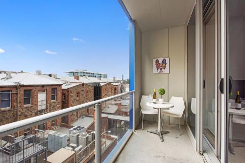 a balcony with a table and a view of the city at Swainson on Bent in Adelaide