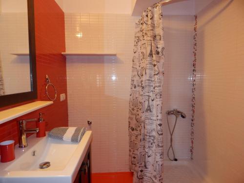 a bathroom with a shower curtain and a sink at Palm House Nikiti - Apartments Vicky in Nikiti