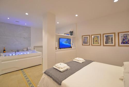 1 dormitorio con cama, bañera y TV en 7 BLU Casa vacanze con idromassaggio, en Catania