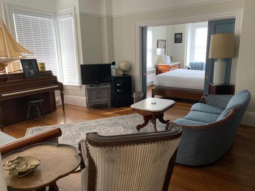 a living room with a bedroom with a bed and a piano at The Bradford in Provincetown
