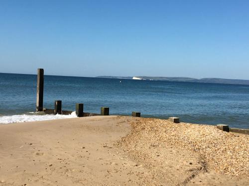 a sandy beach with a pier in the ocean at Southern Breeze Lodge - Adults Only in Bournemouth