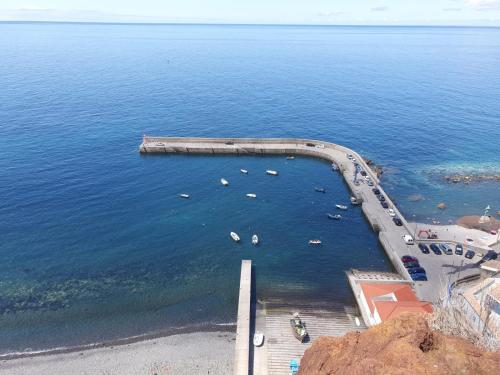 an aerial view of a body of water with boats at Casa da Rocha in Paul do Mar