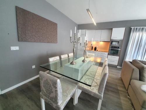 a dining room with a glass table and chairs at Casa da Rocha in Paul do Mar