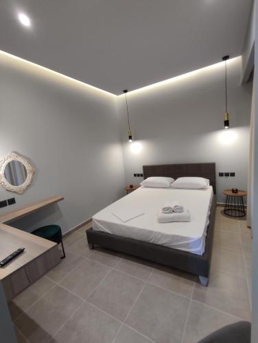 a bedroom with a bed and a table and a desk at Stefani apartments in Methana