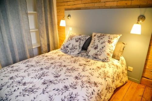 a bedroom with a bed with blue and white sheets and pillows at Duplex centre ville in Saint-Flour