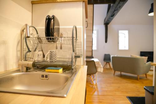 a kitchen with a dish drying rack and a sink at Duplex centre ville in Saint-Flour