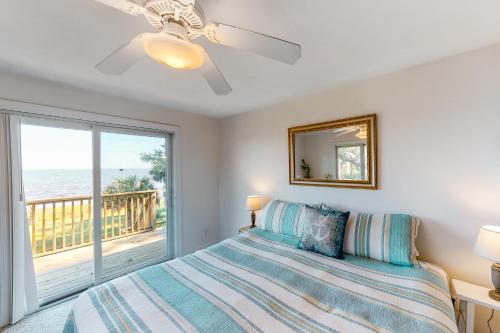 a bedroom with a bed and a view of the ocean at Bliss on the Bay in St. George Island