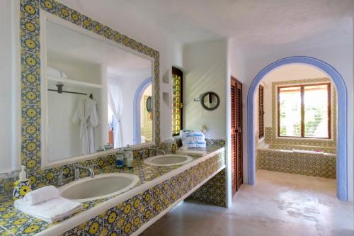 a bathroom with two sinks and a large mirror at Las Alamandas in Quemaro