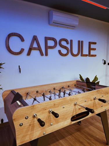a sign for a capple on a wall with weapons at Capsule Gaming balnéo & billard & babyfoot & sauna 2 chambres in Valenciennes