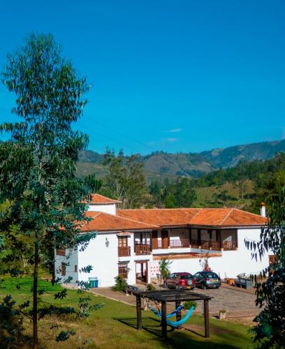 a house with a picnic table in front of it at Hotel Campestre El Portón de Los Jeroglíficos in Ramiriquí