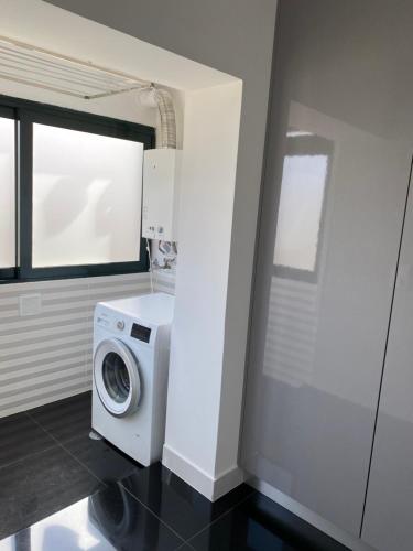 a laundry room with a washing machine and a window at Appartement à Esmoriz de 3 pièces - 72m2 in Esmoriz