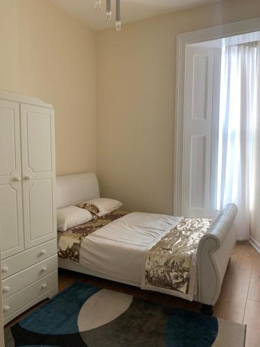 a bedroom with a bed and a dresser and a window at WIGHTHOLIDAY in Ryde