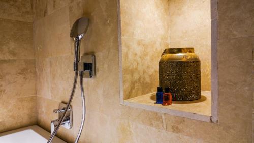 a bathroom with a shower with a jar on a shelf at Pigeon Hotel Cappadocia in Uchisar