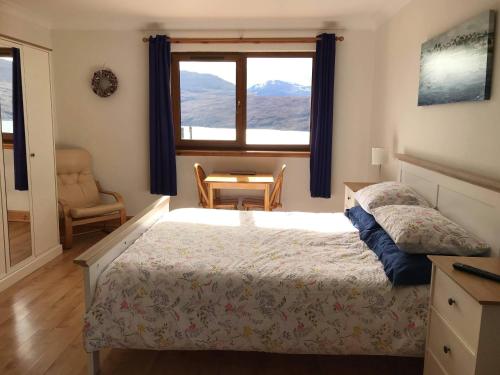 a bedroom with a bed and a window and a chair at Croft No.8 Bed & Breakfast in Ullapool