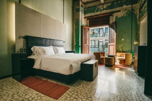 a bedroom with a bed and a large window at Pug Seal Oaxaca in Oaxaca City